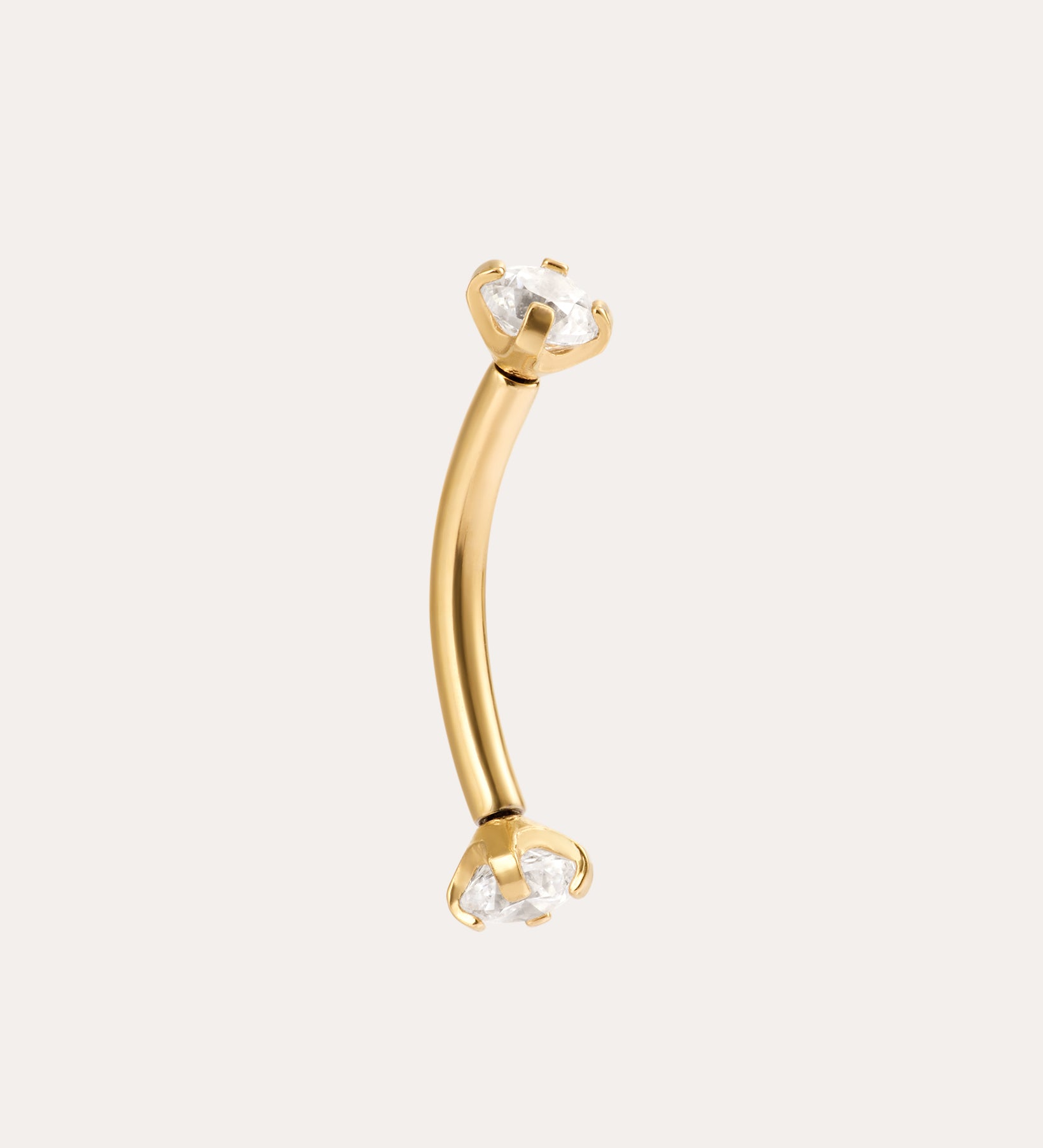 The Crystal Titanium Rook Barbell in Gold features a curved yellow gold PVD design with clear gemstones in prong settings at both ends, displayed against a simple light background.