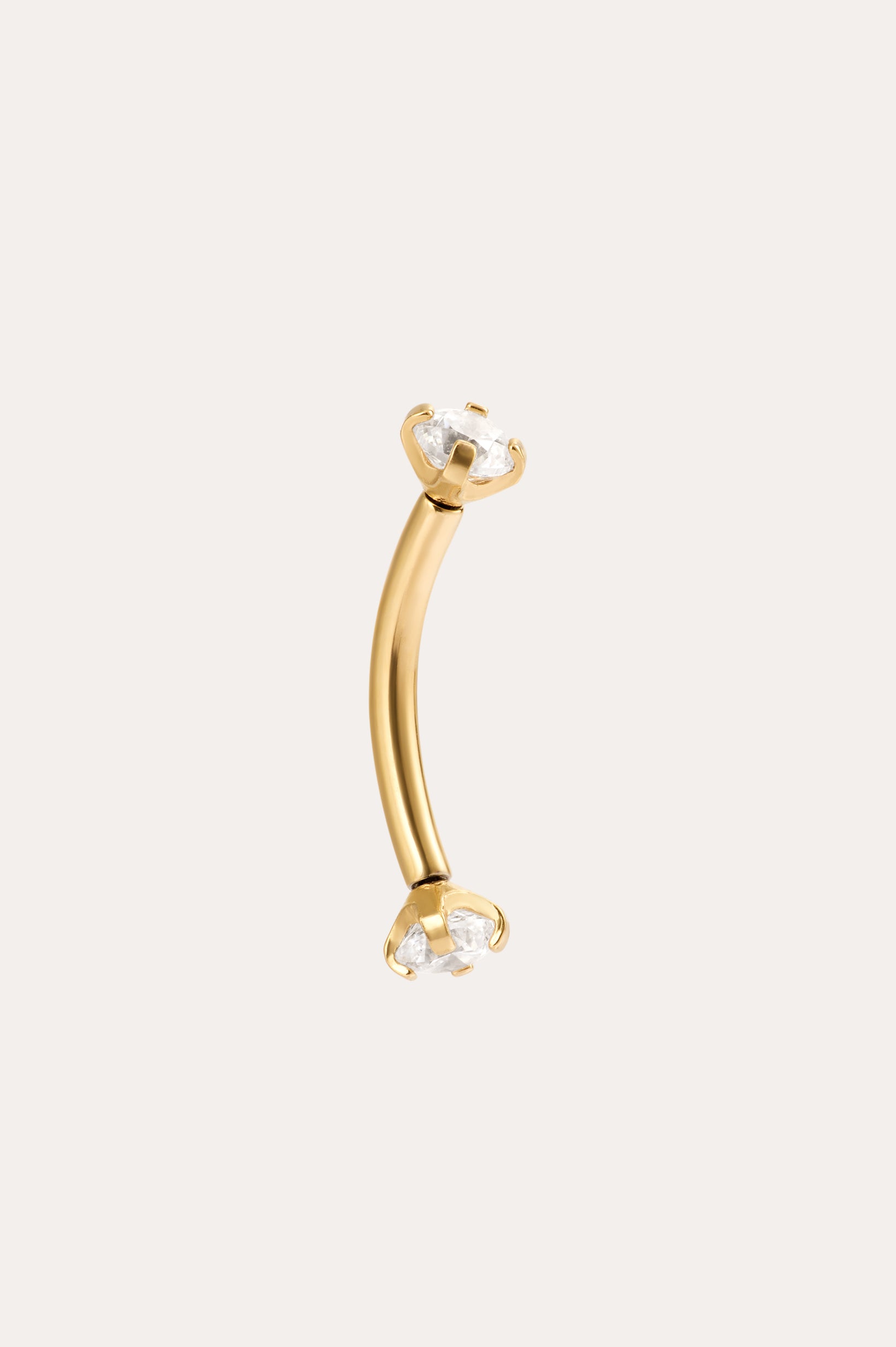 The Crystal Titanium Rook Barbell in Gold features a curved yellow gold PVD design with clear gemstones in prong settings at both ends, displayed against a simple light background.