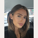 A young woman with straight brown hair and natural makeup sits in a car’s backseat, wearing a black top and a 14K Solid Yellow Gold Lab-Grown Diamond Trinity Flat Back Stud. Text above reads, “SPOTTED ON: DANI OLIVIA NEWMAN.”.