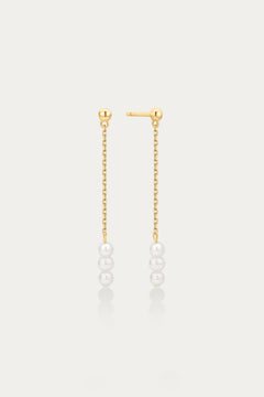 Gold chain earrings with pearls on a light gray background