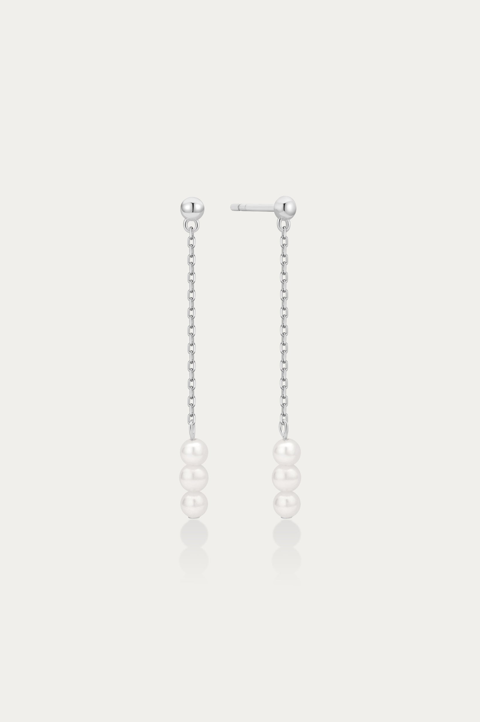 Pair of pearl drop earrings on a light gray background