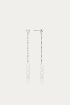 Pair of pearl drop earrings on a light gray background