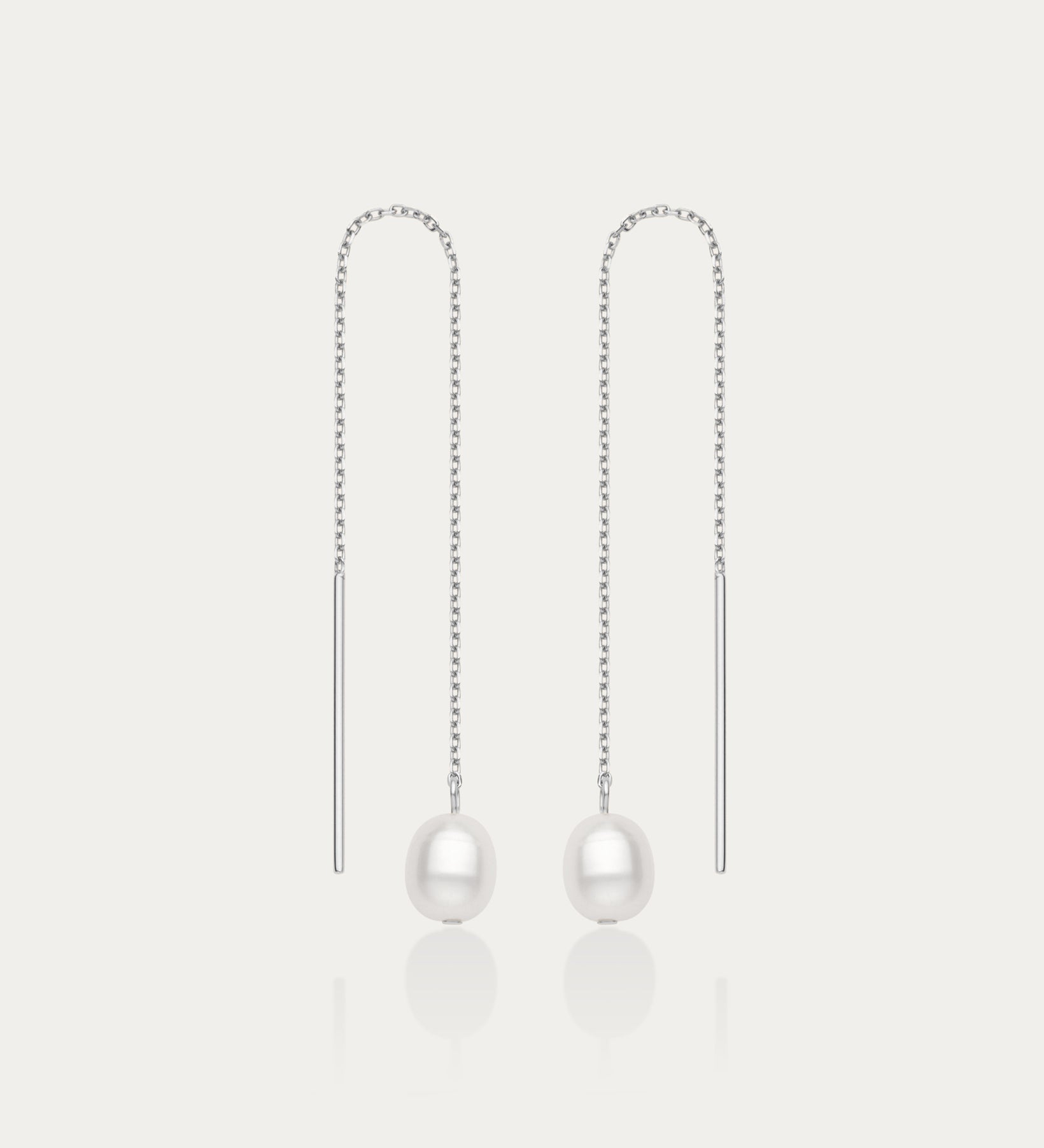 The Eira Pearl Drop Threader Earrings in Silver feature elegant thin chains with a single white pearl at each end, shown on a plain white background.