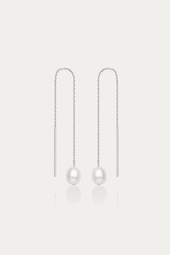 The Eira Pearl Drop Threader Earrings in Silver feature elegant thin chains with a single white pearl at each end, shown on a plain white background.