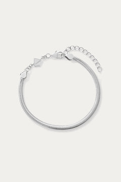 The Estelle Herringbone Chain Bracelet in Silver features a 3mm sleek chain, an adjustable extension, and a small charm by the clasp, shown against a plain white background.