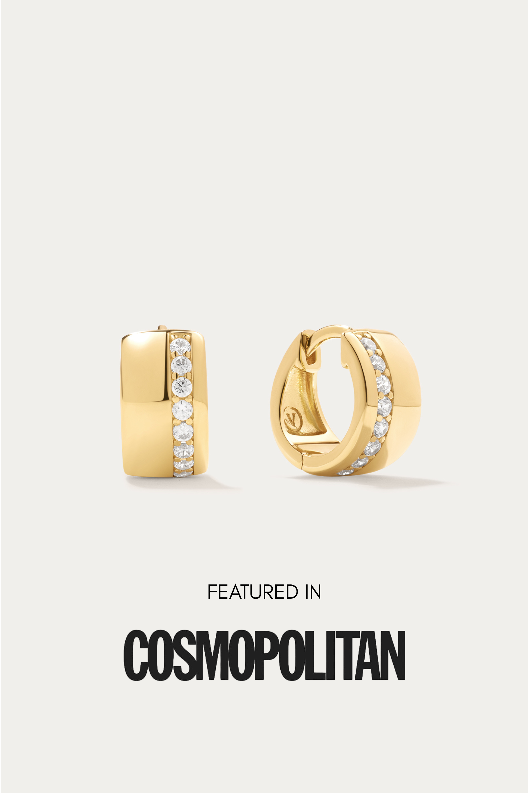 The Juni Pavé Chunky Huggie Earrings in Gold feature a vertical row of small white gemstones and are displayed on a light background above the text "Featured in Cosmopolitan.