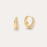 The Georgie Crystal Knife Edge Huggie Hoop Earrings in Gold feature a row of sparkling white gemstones along the front, shown against a plain light background.