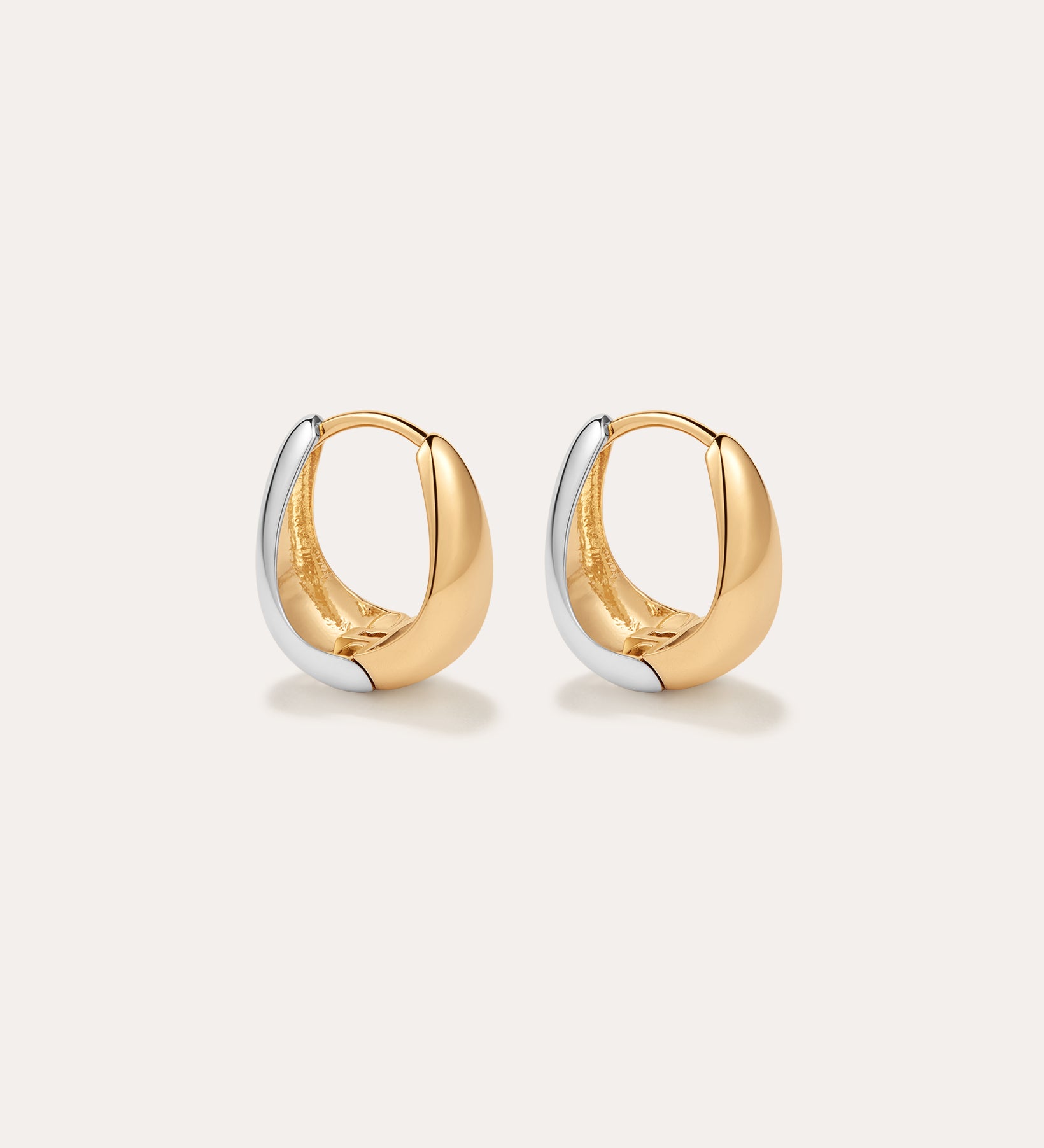 The Gia Reversible 2 Tone Chubby Hoop Earrings feature a smooth, rounded design in 18k gold and sterling silver, shown against a plain light background.