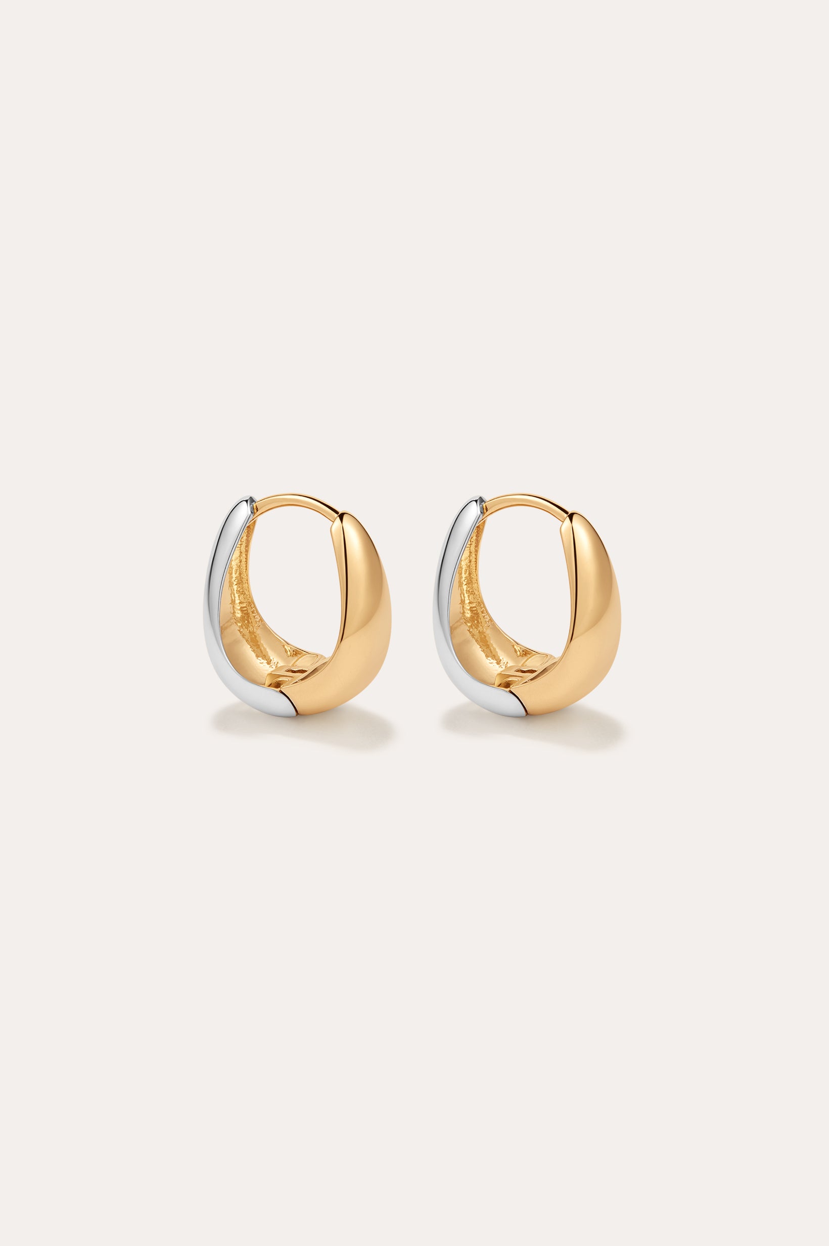 The Gia Reversible 2 Tone Chubby Hoop Earrings feature a smooth, rounded design in 18k gold and sterling silver, shown against a plain light background.