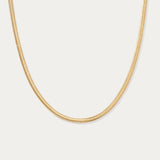 The Estelle Herringbone Chain Necklace in Gold is shown against a plain white background.