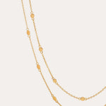 The Simona Double Chain Stacking Necklace in Gold features delicate oval-shaped accents spaced evenly along its length, ideal for stacking or layering, and is shown against a simple, light background.