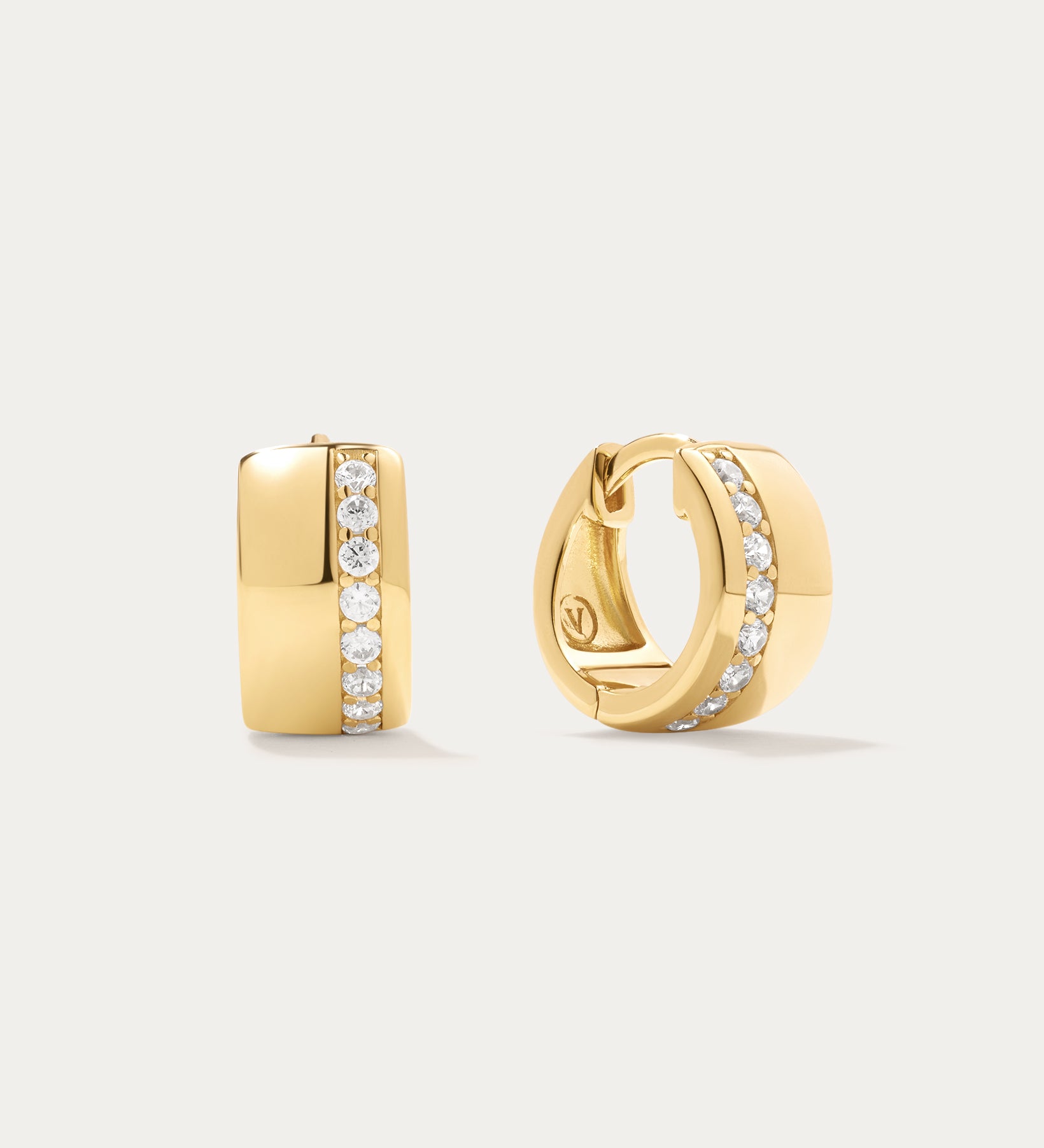 The Juni Pavé Chunky Hoop Earrings in Gold are 18k gold-plated hoops, each accented with a central vertical row of sparkling pavé diamonds, shown against a simple light background.