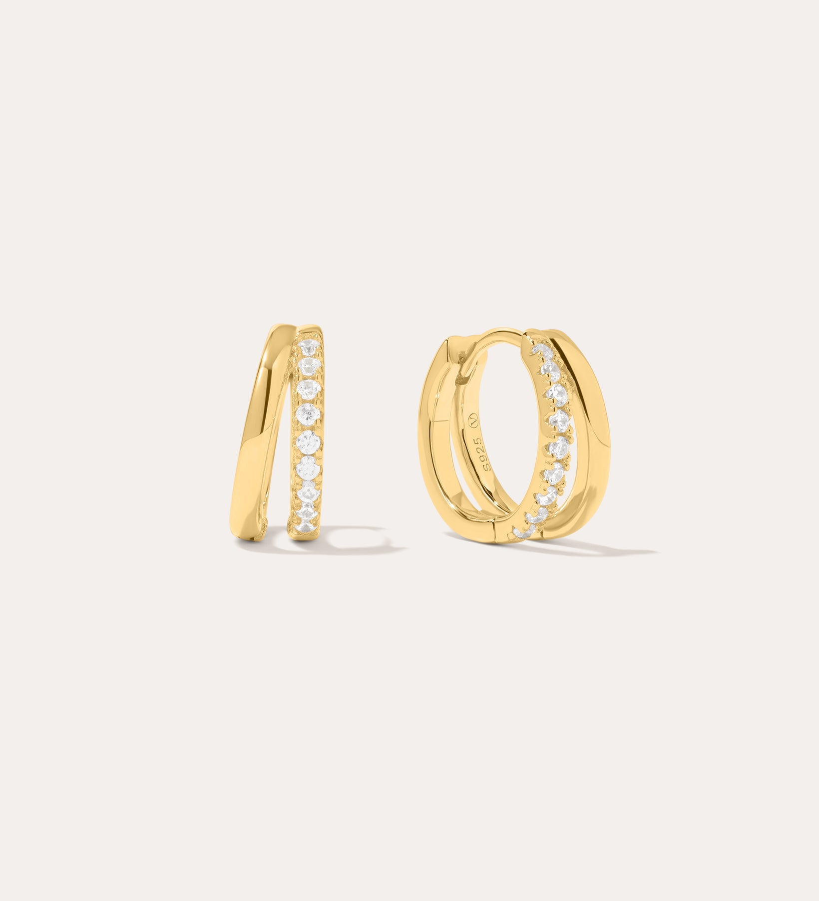 Kira Crystal Double Hoop Huggies in 18k Gold Plated, featuring a row of clear round crystals along the front, are displayed against a plain off-white background.