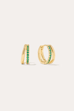 The Kira Crystal Double Hoop Huggies in Gold/Green are small earrings featuring a row of shimmering gemstones on the front, displayed against a plain light background.