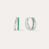 The Kira Crystal Double Hoop Huggies in Sterling Silver/Green feature a row of green gemstones along the front and are displayed against a plain white background.