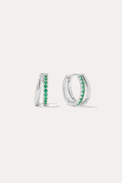 The Kira Crystal Double Hoop Huggies in Sterling Silver/Green feature a row of green gemstones along the front and are displayed against a plain white background.