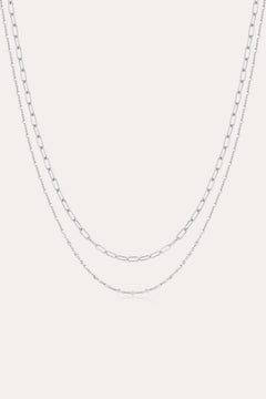 The Mini Paperclip Double Chain Necklace in Silver features two sterling silver layers: an upper chain with elongated oval links and a lower chain with smaller, closely connected links for a simple, elegant look.