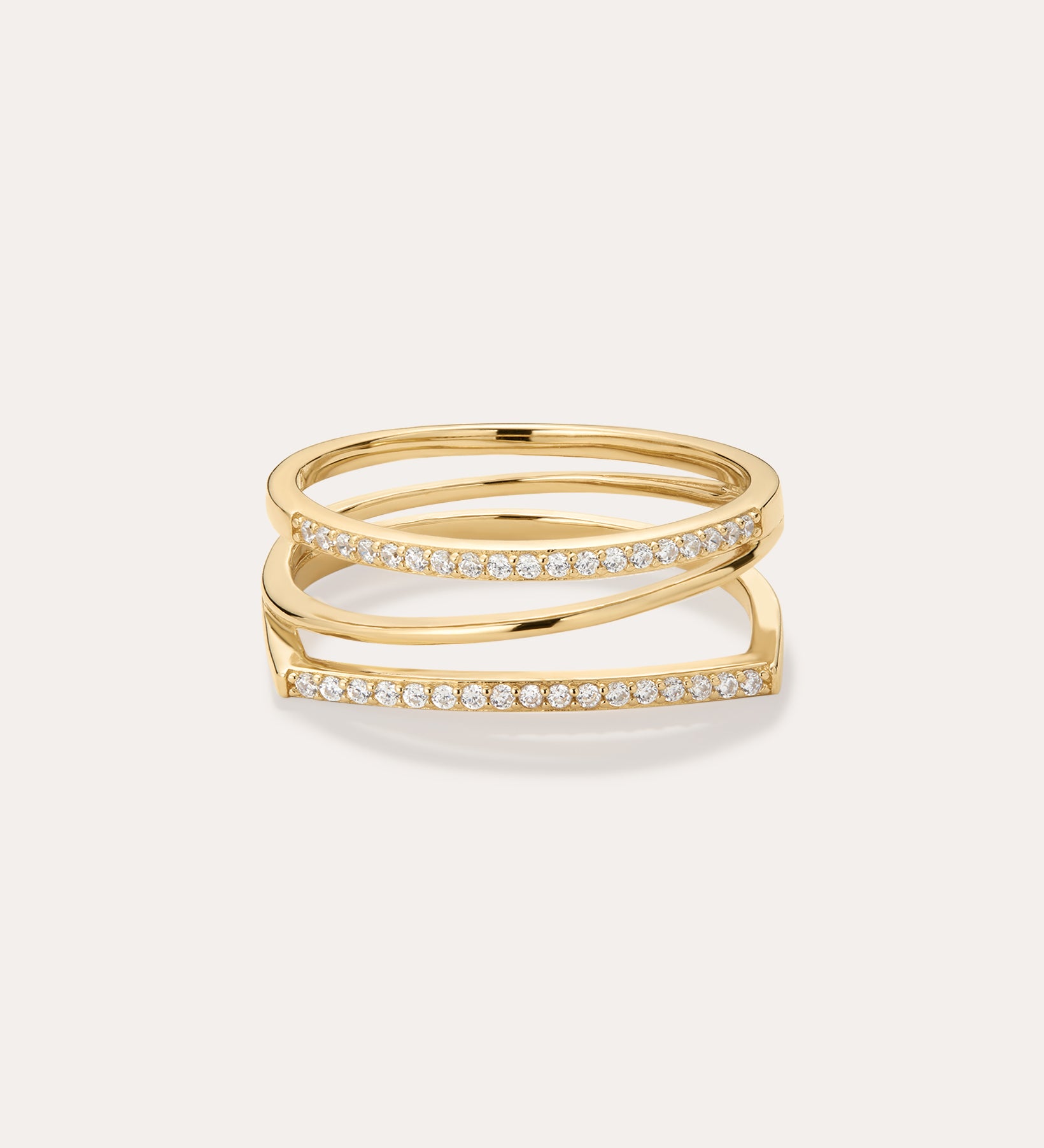 The Nola Pavé Triple Band Ring in Gold features a modern, stacked design with three gold bands, each pavé-set with sparkling diamonds, displayed against a plain light background.