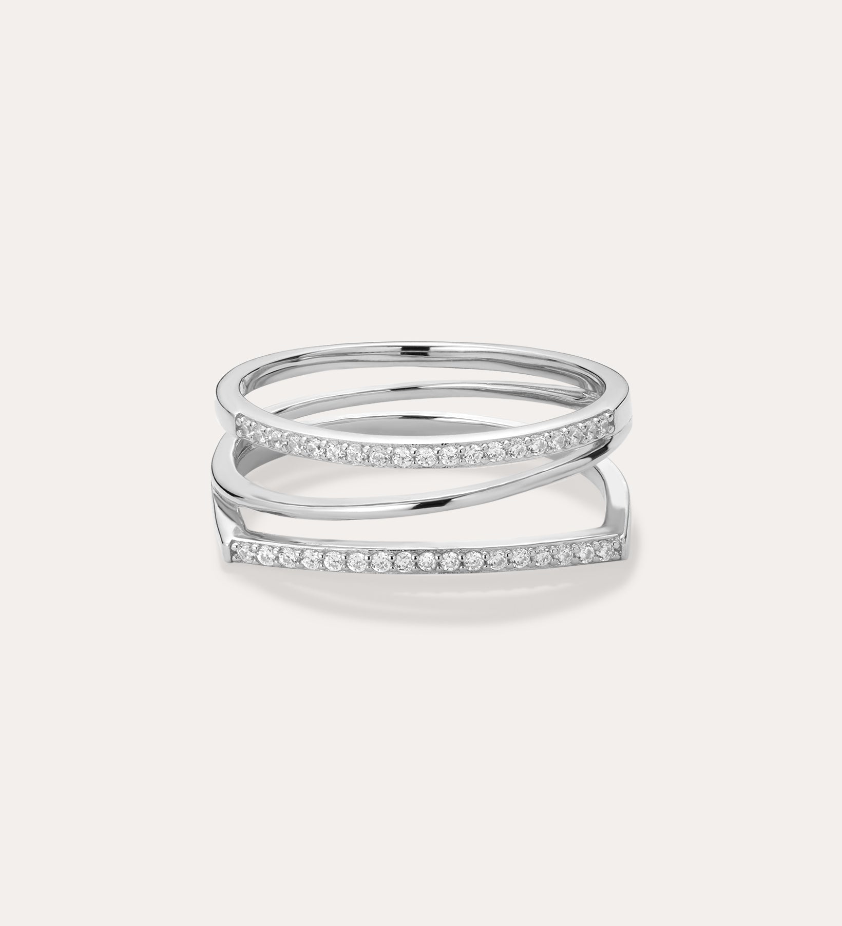 The Nola Pavé Triple Band Ring in Silver features three thin, parallel pavé bands set with sparkling white stones, connected at the sides and displayed on a plain light background.