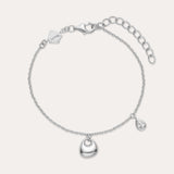 The Nora Double Pendant Bracelet in Silver features a polished heart charm at the center and a small teardrop pendant, both accented with cubic zirconia, plus an adjustable clasp and logo tag near the fastening.