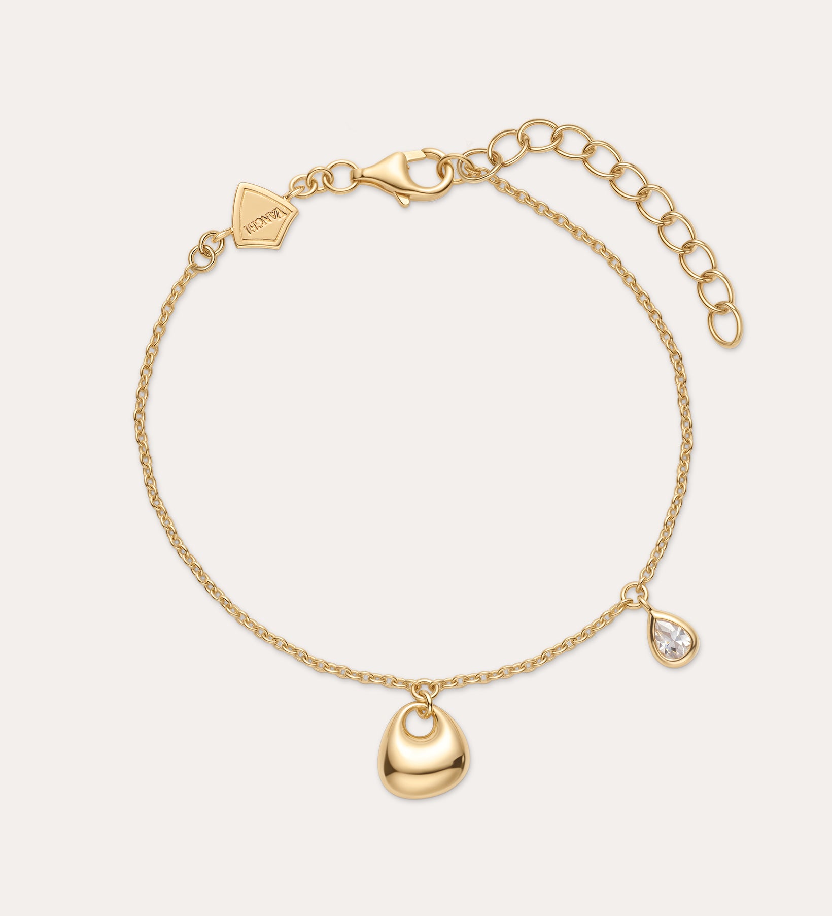 The Nora Double Pendant Bracelet in Gold features an adjustable clasp, a gold heart charm, and a teardrop-shaped cubic zirconia pendant for subtle sparkle.