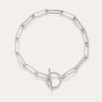 The Paperclip Toggle Bracelet in Silver features elongated oval links and a circular toggle clasp, displayed on a plain light background.