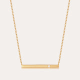 The Regina Horizontal Bar Pendant Necklace in Gold features a minimalist horizontal bar with an off-center cubic zirconia, making it perfect for lovers of simple, elegant jewelry.