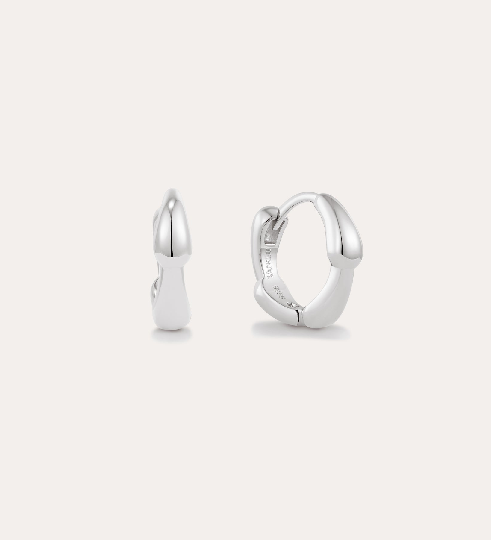 The Colette Droop Link Huggie Earrings in Silver are shown against a white background, with one earring facing front and the other from the side to display their sleek, polished, and minimalist design—ideal for everyday wear.