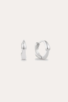 The Colette Droop Link Huggie Earrings in Silver are shown against a white background, with one earring facing front and the other from the side to display their sleek, polished, and minimalist design—ideal for everyday wear.