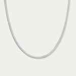 The Estelle Herringbone Chain Necklace in Silver is a sleek, minimalist chain shown against a plain white background.