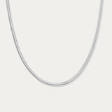 The Estelle Herringbone Chain Necklace in Silver is a sleek, minimalist chain shown against a plain white background.