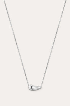 Silver necklace with a curved pendant on a light gray background