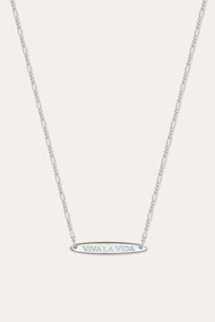 The Viva La Vida Bar Chain Necklace in Silver features a delicate, adjustable Figaro chain and an engraved oval horizontal bar pendant with VIVA LA VIDA in capitals, shown on a plain white background.