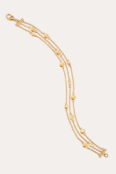 A triple layered gold bracelet with chain links and small circular embellishments, fastened with a lobster clasp.