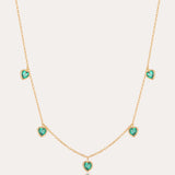 Thea Green Heart Pendant Gold Necklace features five small green cubic zirconia hearts evenly spaced on an adjustable gold chain, shown against a plain light background.