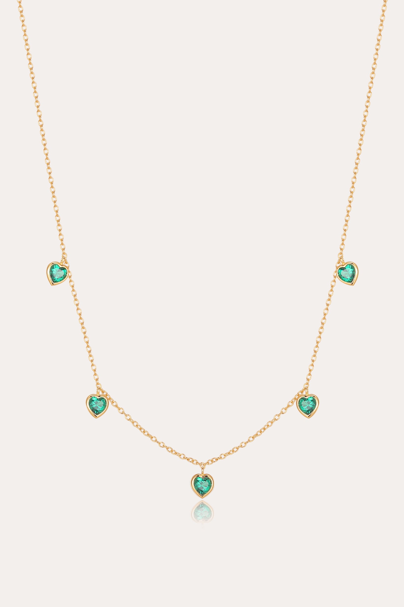 Thea Green Heart Pendant Gold Necklace features five small green cubic zirconia hearts evenly spaced on an adjustable gold chain, shown against a plain light background.