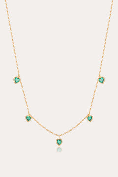 Thea Green Heart Pendant Gold Necklace features five small green cubic zirconia hearts evenly spaced on an adjustable gold chain, shown against a plain light background.