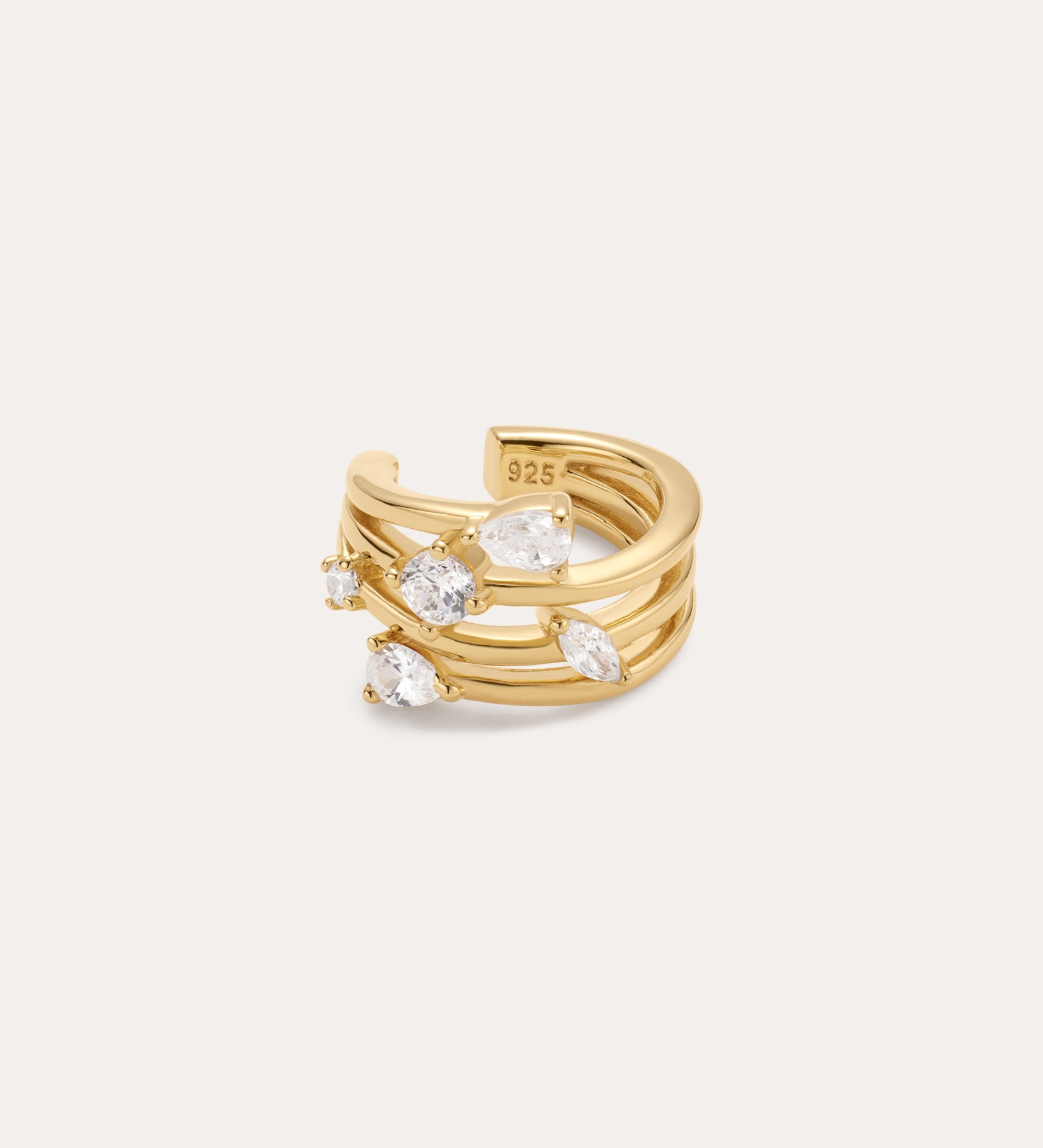 The Vale Crystal Ear Cuff in Gold features three parallel gold bands with clear gemstones and a “925” stamp inside, indicating sterling silver beneath the gold finish. Perfect for adding sparkle to your ear stack.
