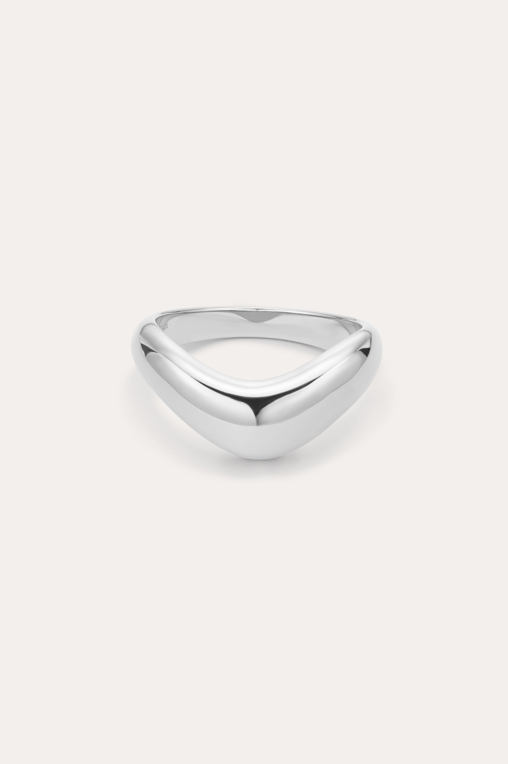 The Vava Plain Chunky Curved Wave Ring in Silver features a polished, silver V-shaped wave design with a smooth, rounded surface. Photographed against a light background, its ideal for minimalist jewelry lovers.