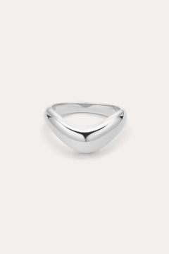 The Vava Plain Chunky Curved Wave Ring in Silver features a polished, silver V-shaped wave design with a smooth, rounded surface. Photographed against a light background, its ideal for minimalist jewelry lovers.