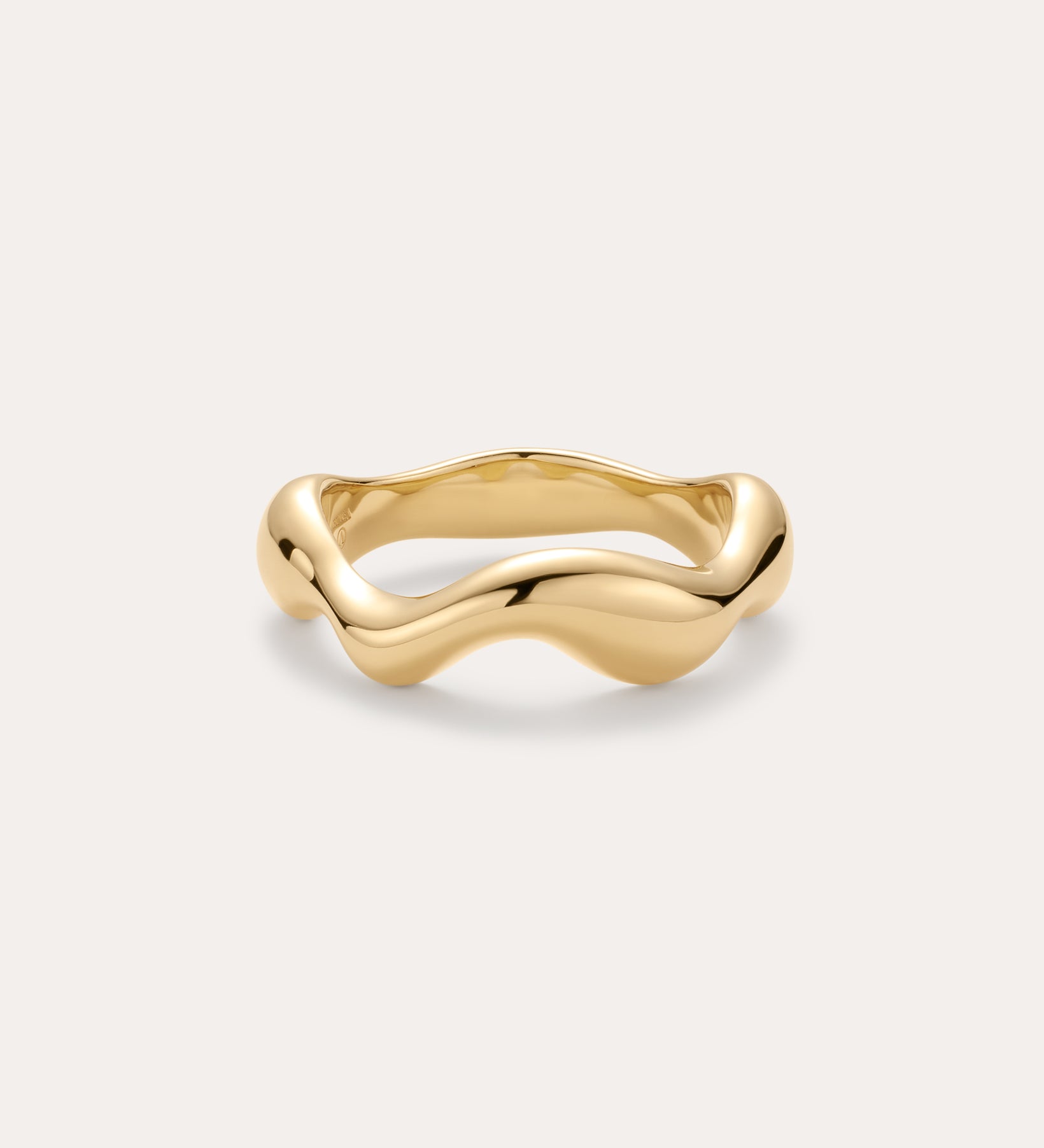 The Vica Fluid Wave Chunky Band Ring in Gold features a bold, wavy band design and is displayed on a simple, light background.