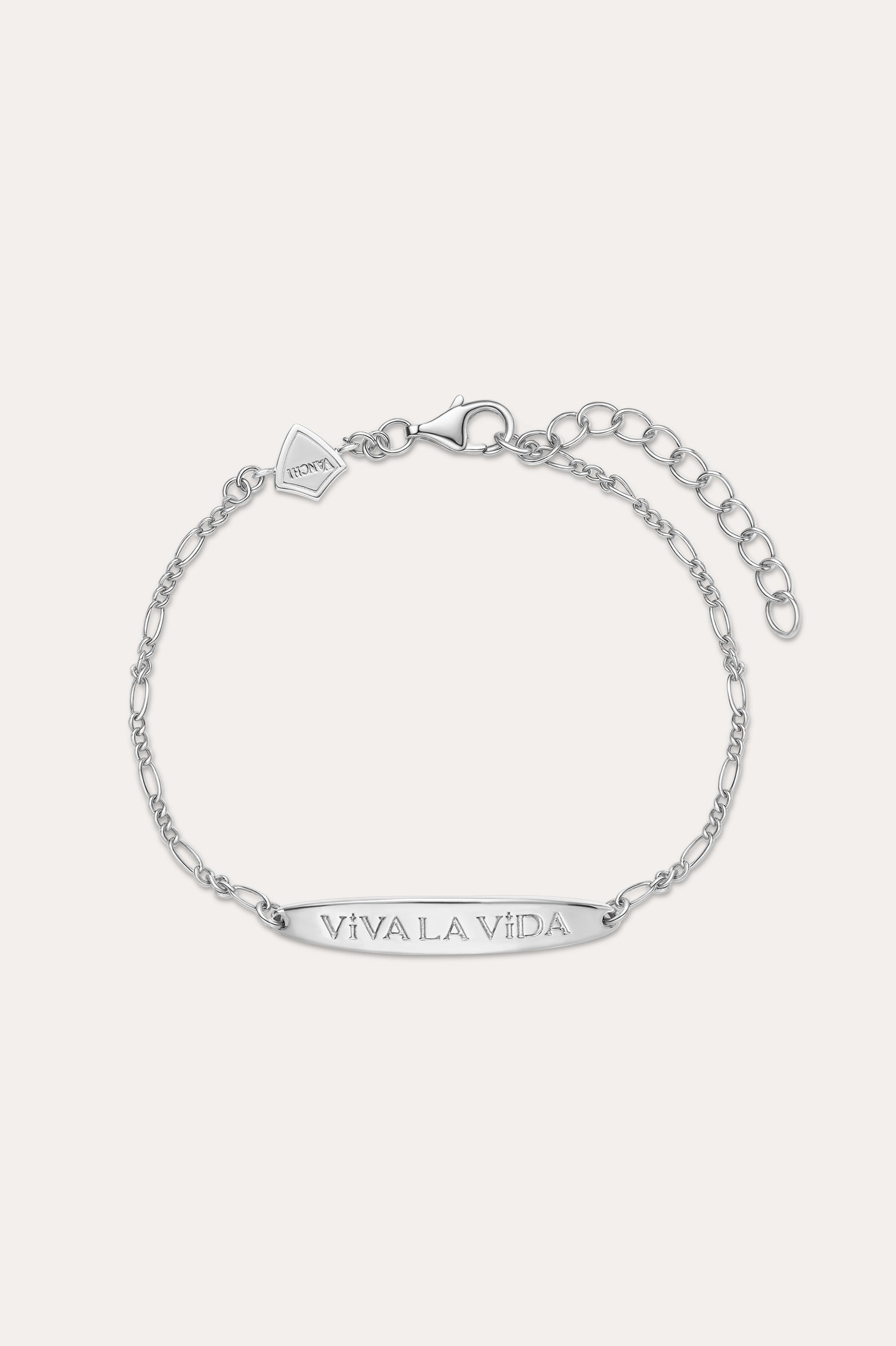 The Viva La Vida Bar Chain Bracelet in Silver features an adjustable Figaro chain, a rectangular plate engraved with VIVA LA VIDA, and a small embossed logo tag. Pair it with our Viva La Vida necklace for a matching set.
